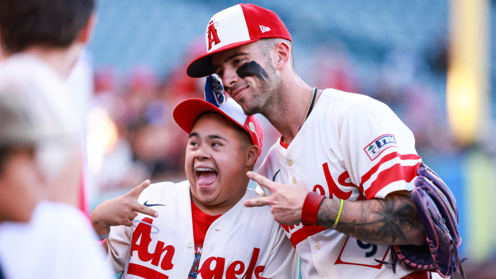 Zach Neto poses with a fan in the Angels' City Connect jerseys before a game on July 29, 2025. (Nicole Vasquez/MLB)