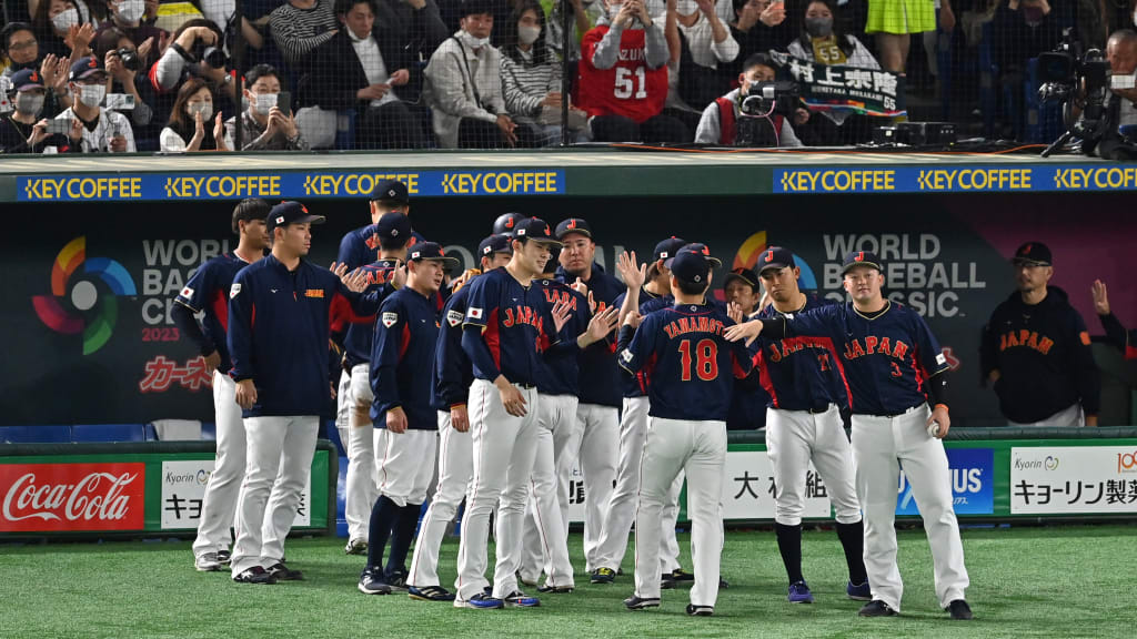 Masahiro Tanaka gets a pat on the No. 18 on his back in a previous World Baseball Classic. (Getty Images)