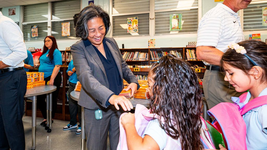 Marlins general manager Kim Ng distributes pencils to students. (Photo credit: Marlins)