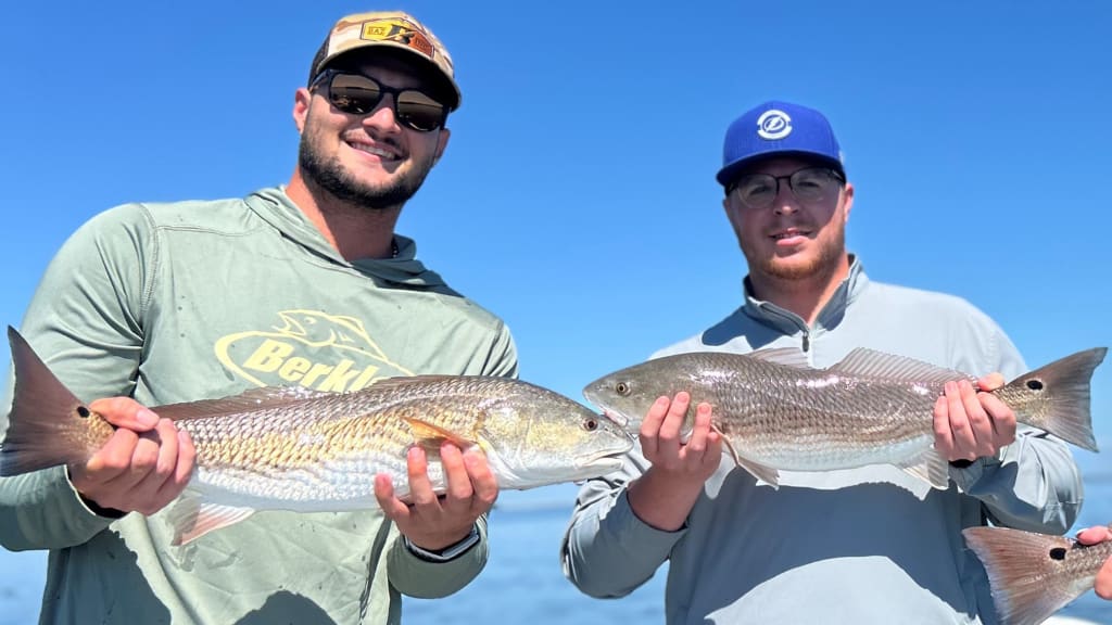 Shane McClanahan (left) and Rays home clubhouse assistant Jonah McElwee pose with redfish. / Photo courtesy of Jake Rogers