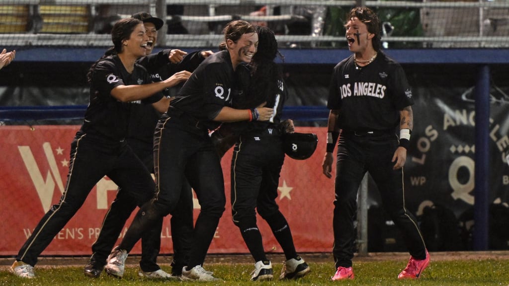 The Queens' Keira Izumi (No. 1) is congratulated by teammates after scoring in the seventh inning.