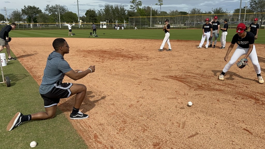 Xavier Edwards rolling a grounder to a camper