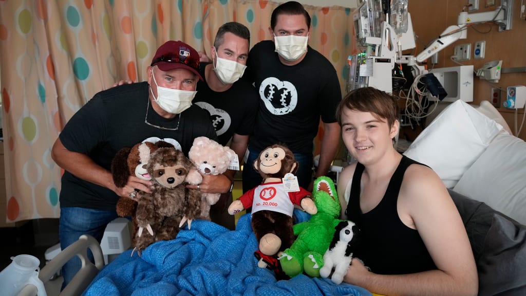 Umpires make hospital visits to deliver bears and other stuffed animals to children.