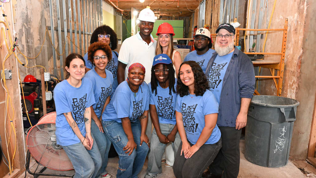 Ryan and Krystle Howard pose for a photo with workers during the 2026 All-Star Legacy Tree House Books literacy clubhouse renovation at Tree House Books. (Photo by Drew Hallowell/MLB Photos via Getty Images)