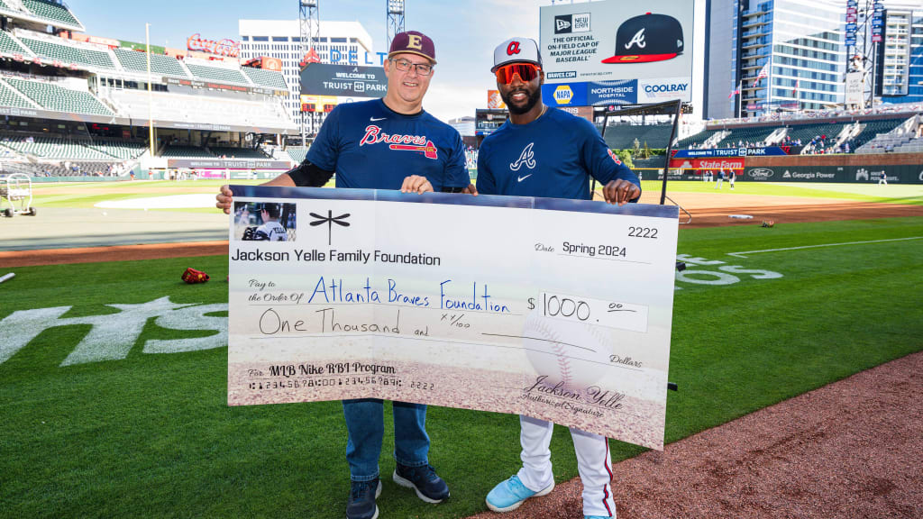 The Braves present a check of $1,000 to the Jackson Yelle Family Foundation.