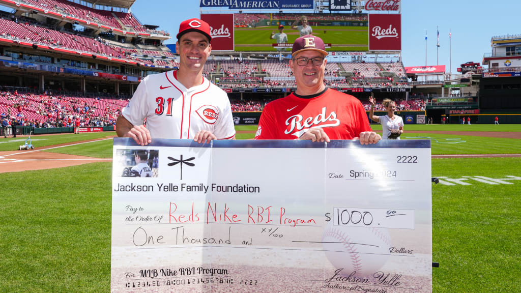 Scott Yelle presents a check of $1,000 to the Reds Nike RBI Program on behalf of the Jackson Yelle Family Foundation.