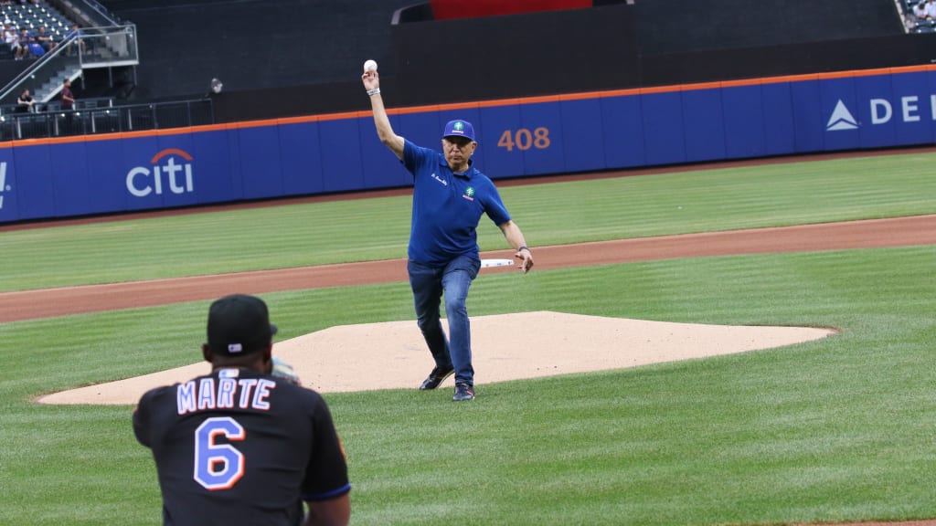 El doctor Ramón Tallaj es captado en el momento que realiza el lanzamiento de la primera bola en Citi Field, recibida por el pelotero Starling Marte.