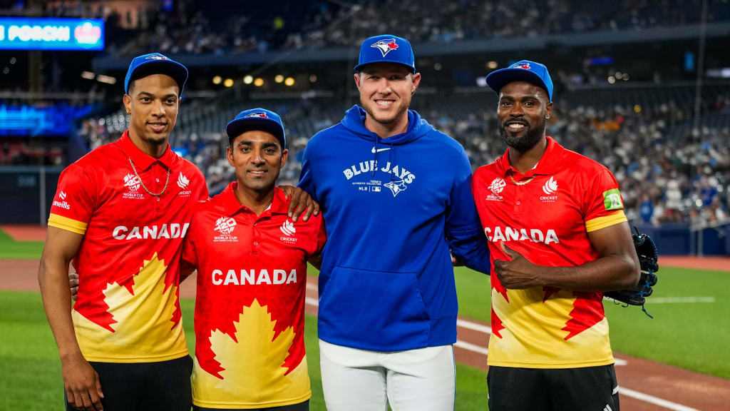 Saad Zafar (middle) and teammates Nicholas Kirton (left) and Jeremy Gordon (right) pose for a photo with Toronto reliever Nate Pearson