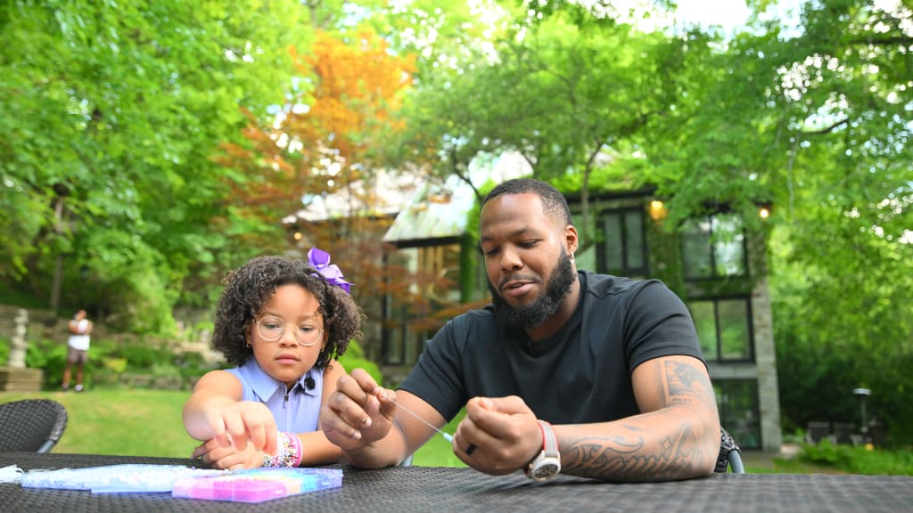 Vladimir Guerrero Jr. and his daughter, Vlaimel, make friendship bracelets.