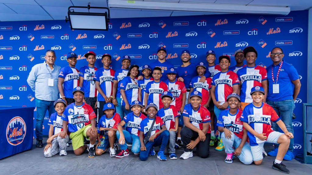 **Las estrellas de los Mets de Nueva York, Juan Soto y Freddy Peralta, comparten junto a la delegación del Team Liguilla de Cristo Rey de Santo Domingo, durante el emotivo encuentro celebrado en Citi Field.**