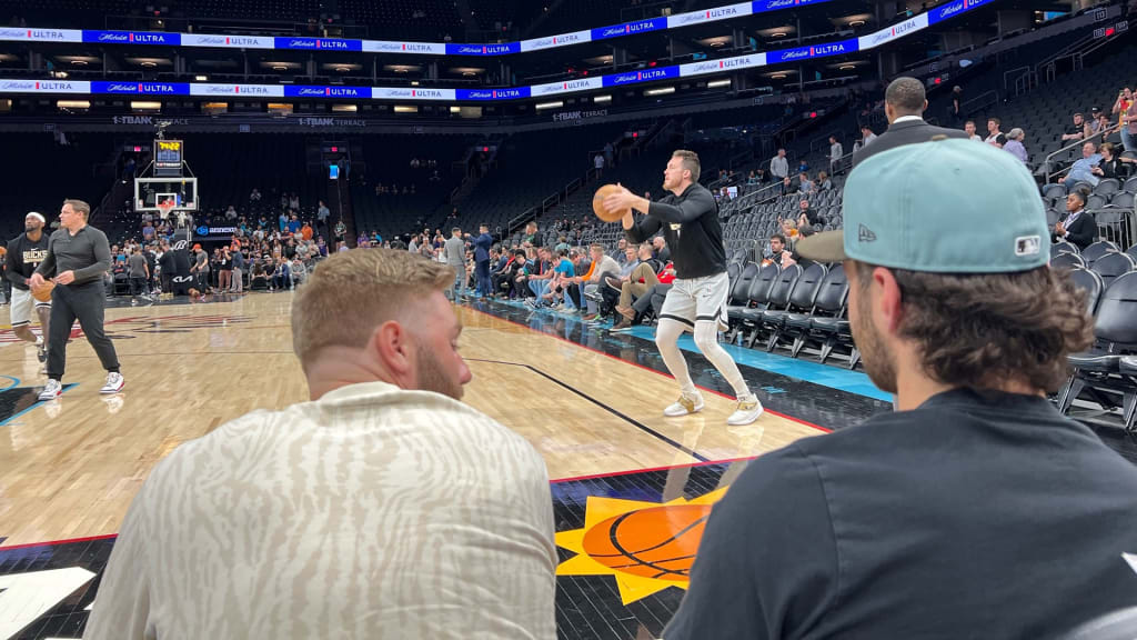 Owen Miller and Garrett Mitchell watch Pat Connaughton warm up as the Bucks prep for the Suns