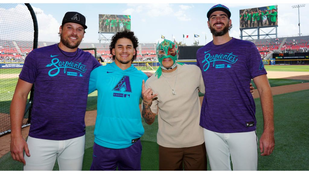 Alek Thomas posa junto al luchador Rey Fénix y sus compañeros Kevin Ginkel (37) y Ryan Thompson (81) de los D-backs en el Estadio Alfredo Harp Helú.