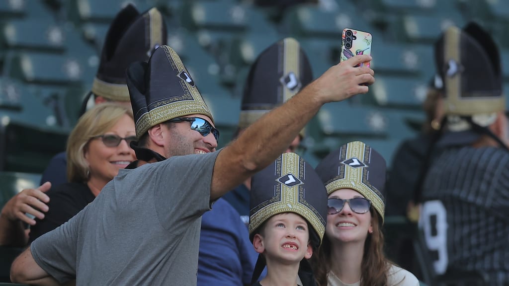 Fans pose for a selfie while donning their Pope Hats
