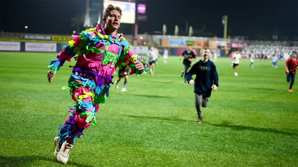 Fans stream across the field during the Piñata Run in the sixth inning.