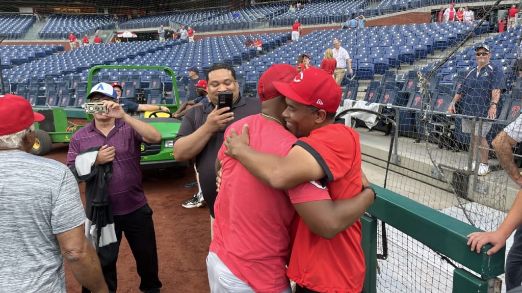 Robinson hugs his father, "Little Chuck," on the field before the Reds took on the Phillies at Citizens Bank Park.