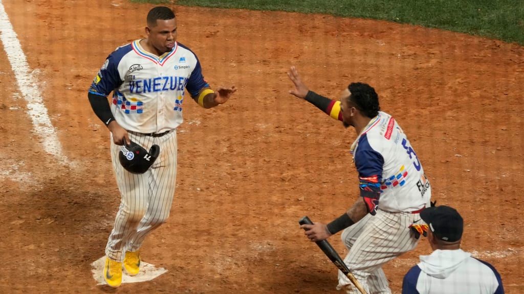 Venezuela's Isaias Tejada (left) celebrates with his teammates after scoring the winning run against the D.R.