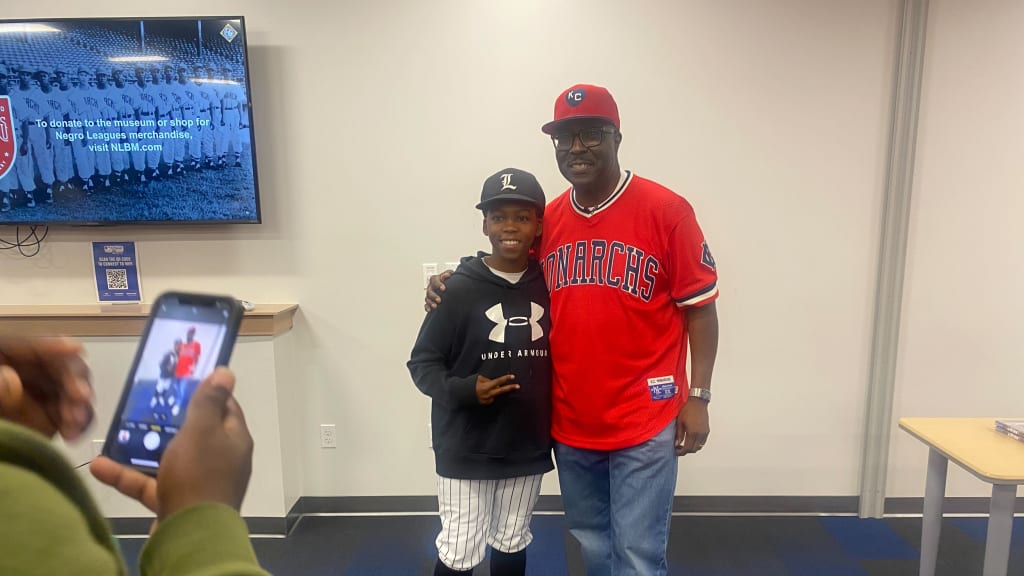Negro Leagues Baseball Museum president Bob Kendrick poses for a photo with a youngster during his visit to the Texas Rangers Youth Baseball Academy.