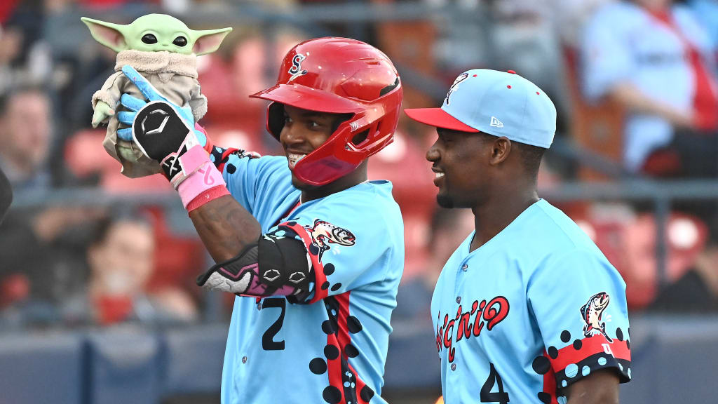 Adael Amador (left) holding up a stuffed Baby Yoda alongside teammate AJ Lewis (right).