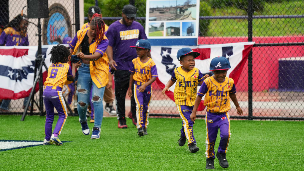 Local youth run on the field during the field dedication ceremony at Willie Mays Park.
