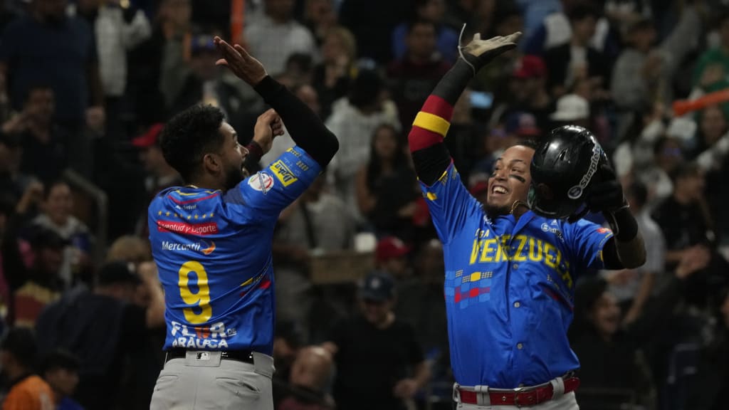 Venezuela's Orlando Arcia (right) celebrates with José Rondón after scoring a run against Colombia.