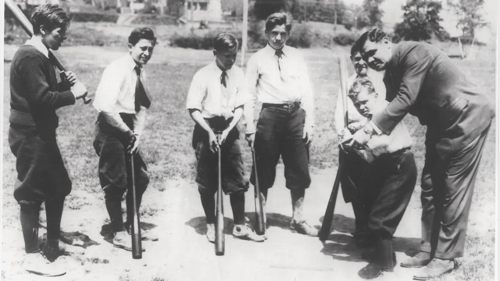 Babe Ruth gives batting lessons to six New Jersey orphans on the ballfield next to the Passaic Home and Orphan Asylum in 1933.