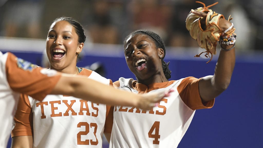 Texas infielder Viviana Martinez (23) and outfielder Adayah Wallace (4) celebrate after beating Texas Tech during the first game of the NCAA softball Women's College World Series. (AP Photo/Kyle Phillips)