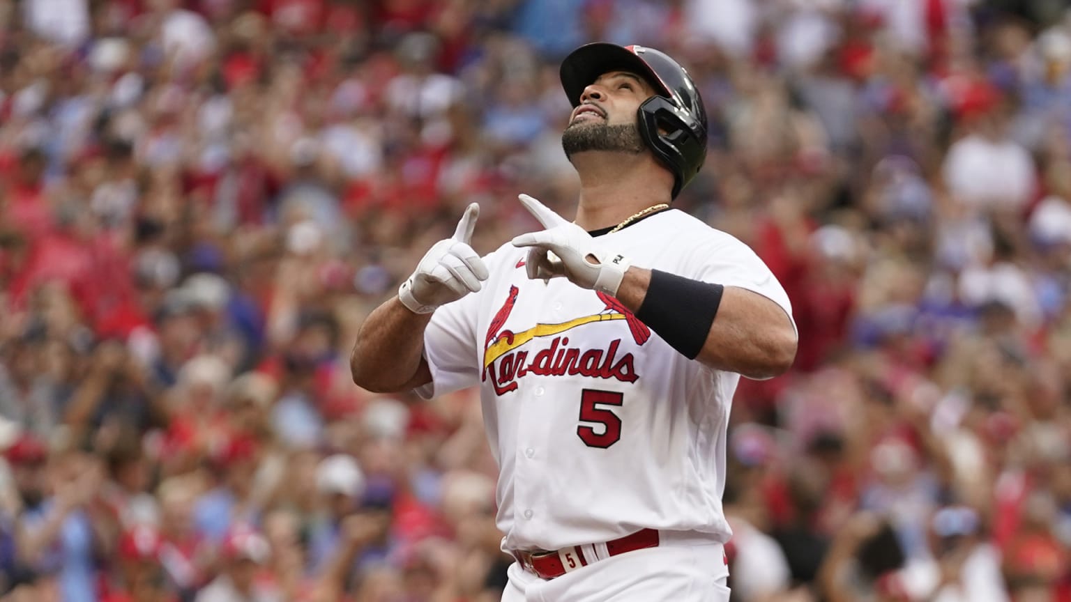 Albert Pujols points and looks to the sky after hitting a home run