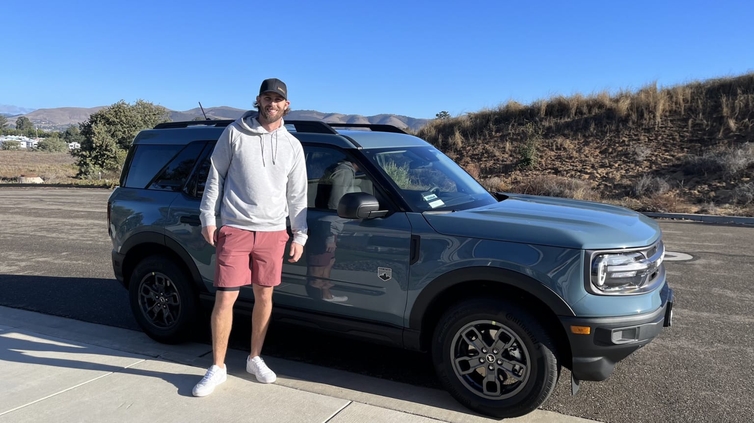 Jeff McNeil standing in front of the SUV bought for him by Francisco Lindor