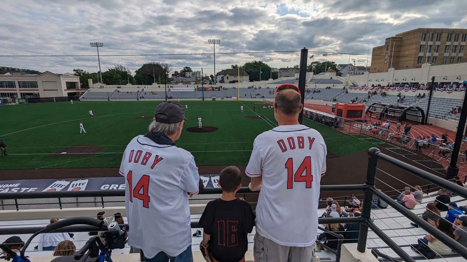 A pair of fans wearing Larry Doby jerseys watch a baseball game