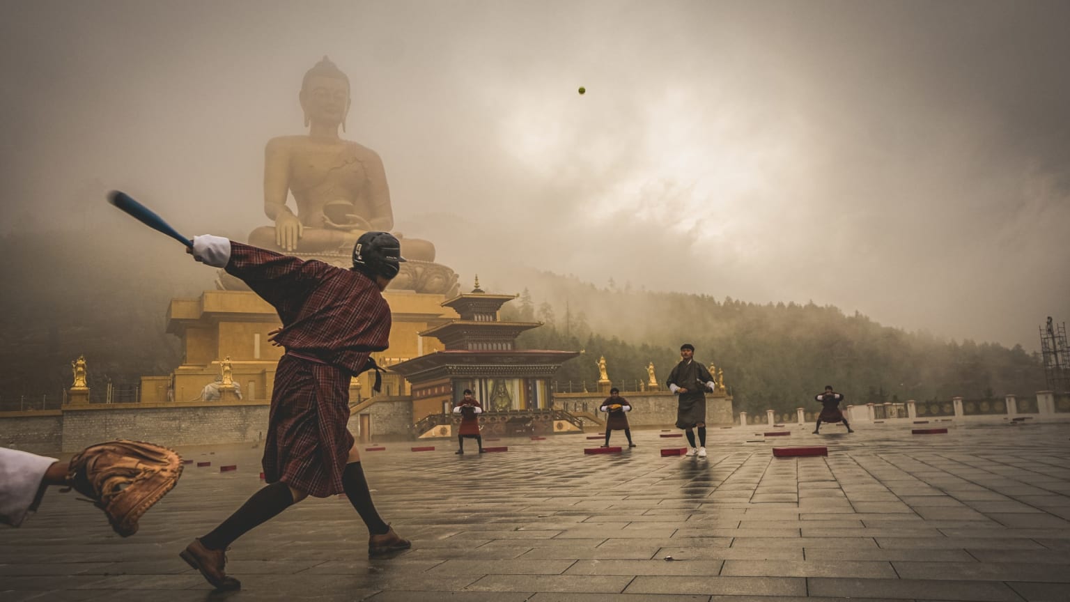 Playing baseball in front of Bhutan's famous Buddha Dordenma statue