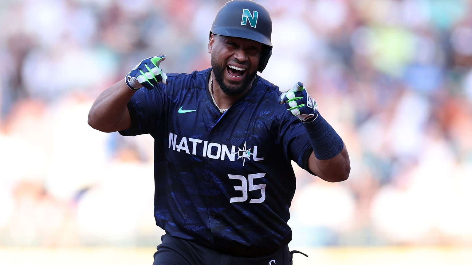 Elias Díaz smiles and points as he rounds the bases