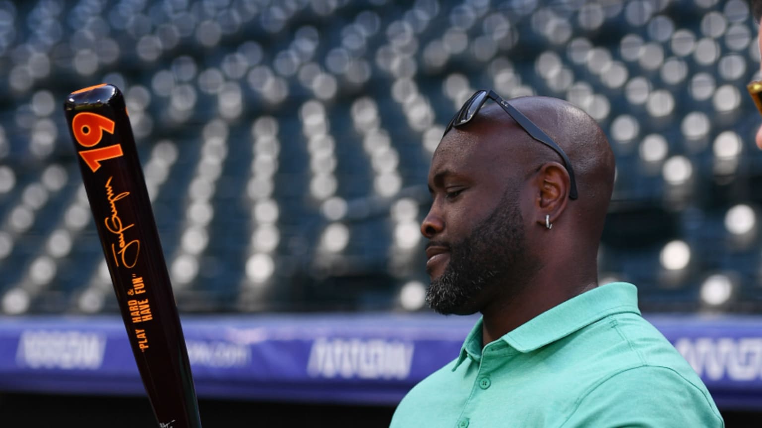 Tony Gwynn Jr. holds a bat featuring his dad's signature and uniform number