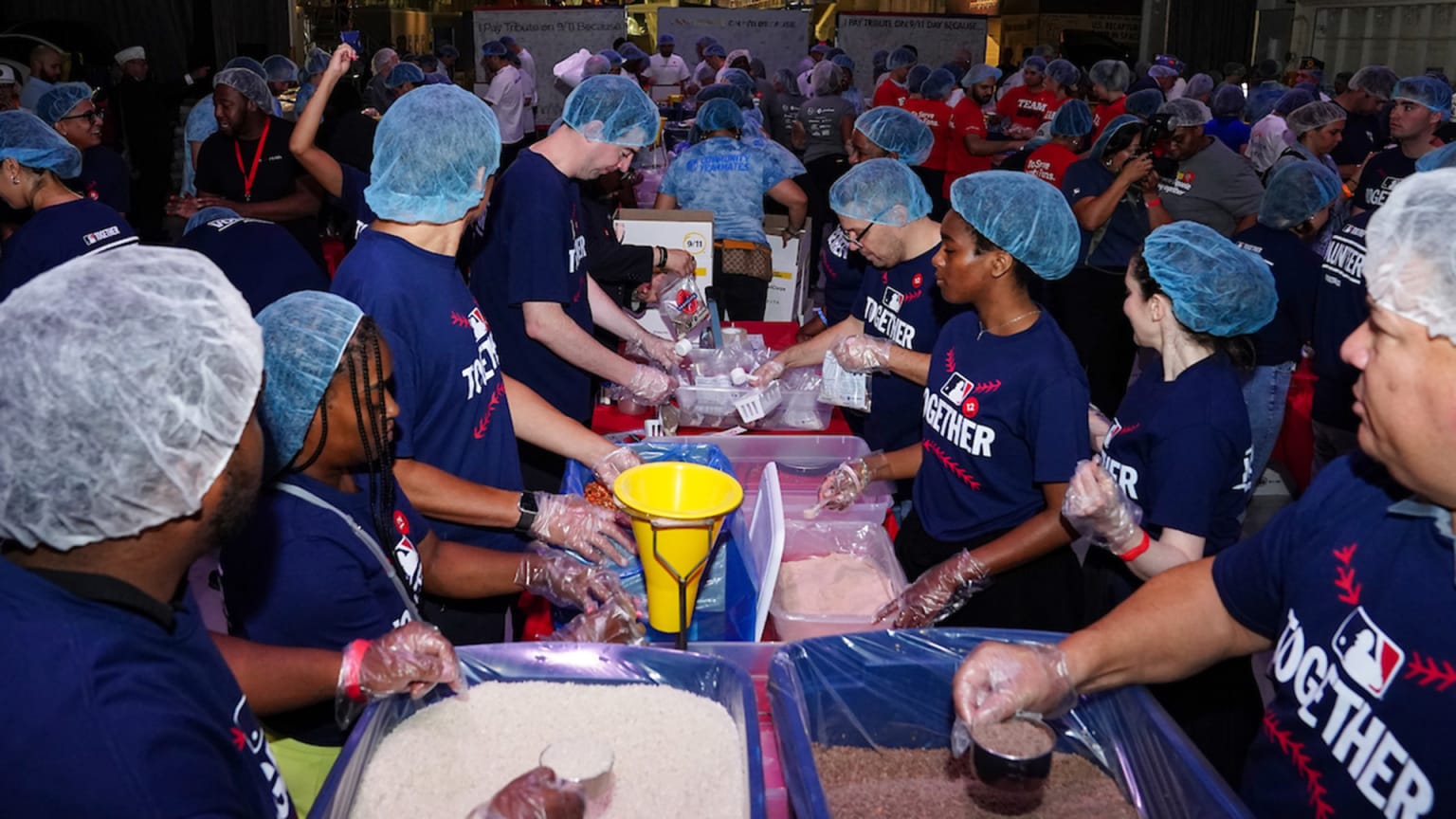 MLB volunteers, including current and former players, pack meals