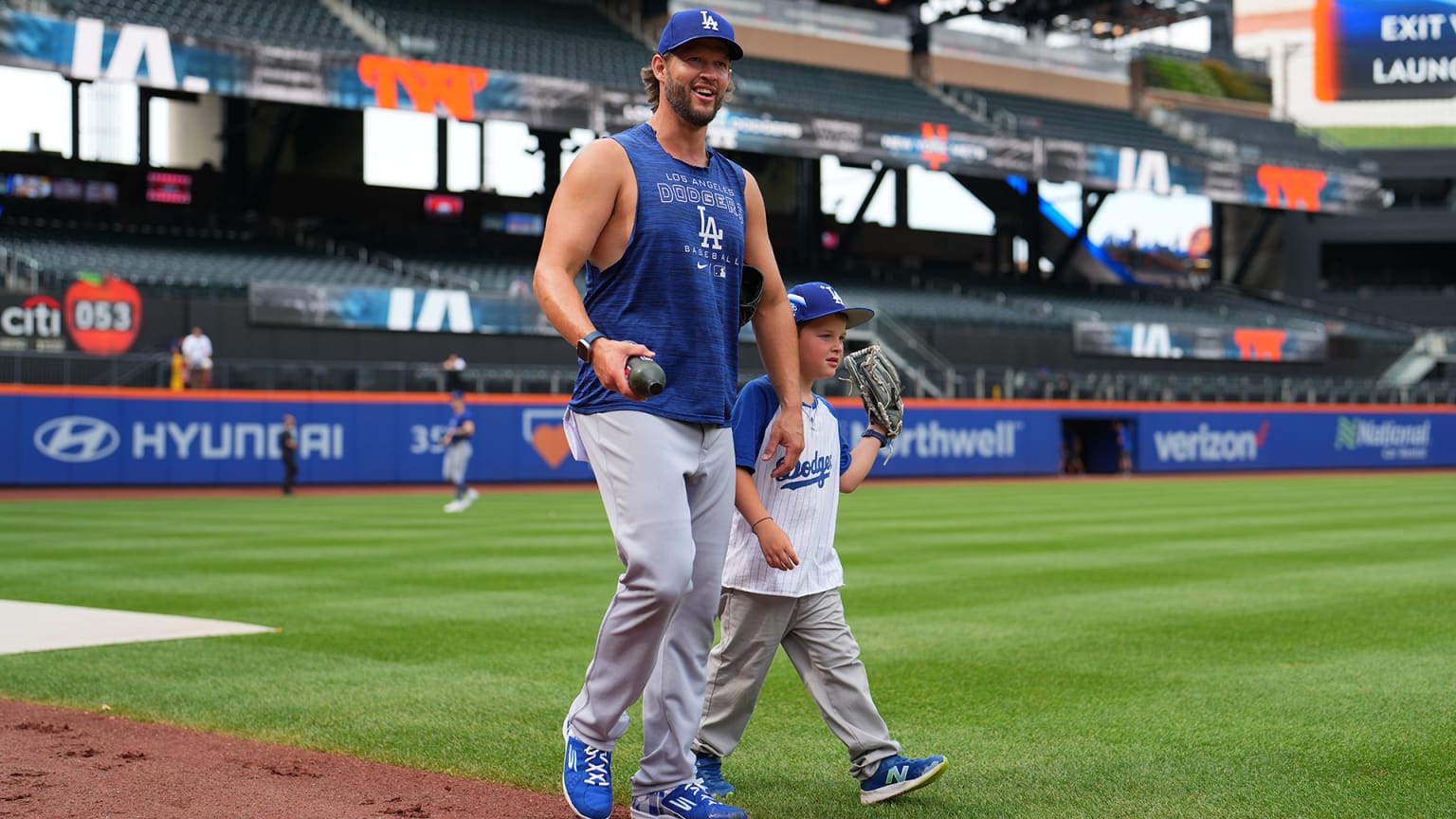 Dodgers pitcher Clayton Kershaw walking on field at Citi Field with son Charley