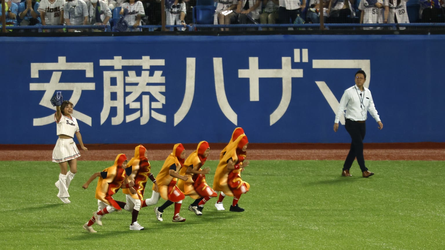 Kids dressed as hot dogs race on a baseball field