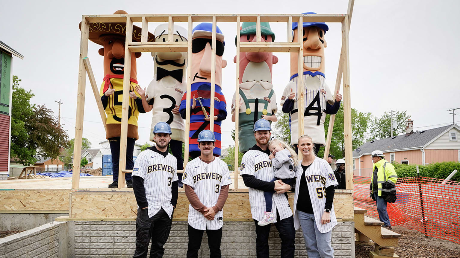 Brewers players pose for a photo wearing hardhats