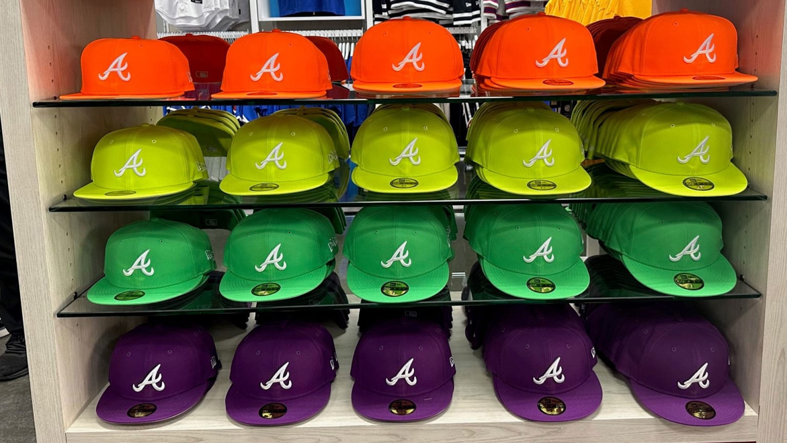 Atlanta Braves caps in orange, neon yellow, lime green and purple