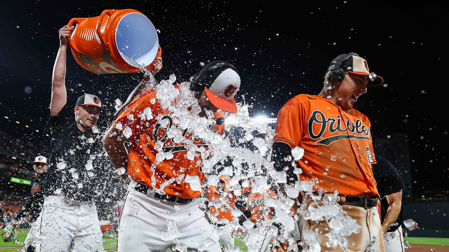 Grayson Rodriguez and Gunnar Henderson receive a Gatorade shower from teammates