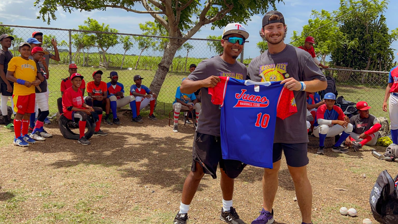 Luke Savage holds up a jersey with a young player