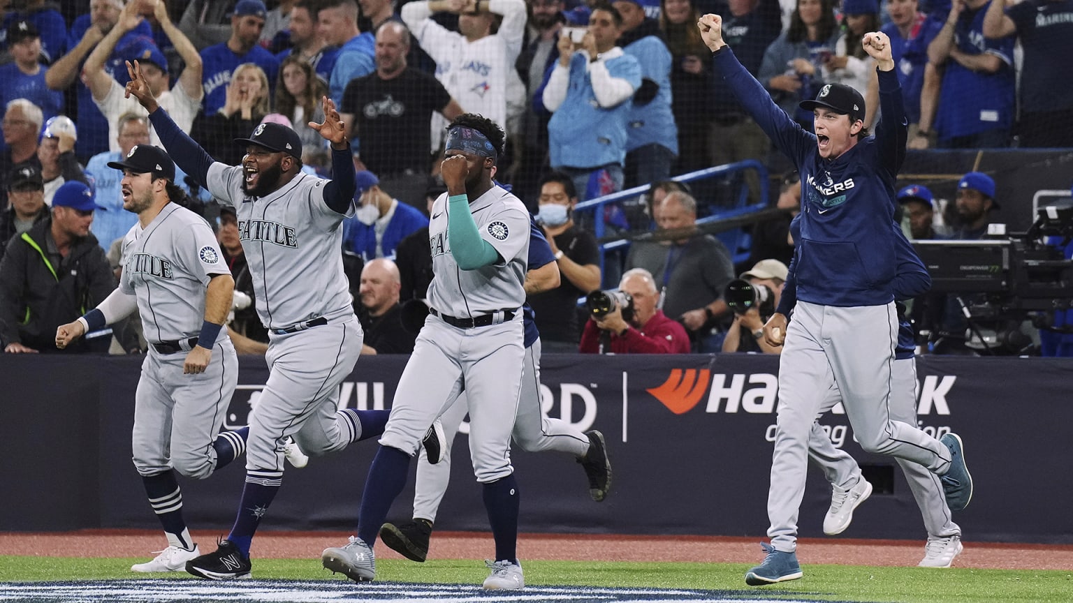 Mariners players run on to the field after defeating the Blue Jays