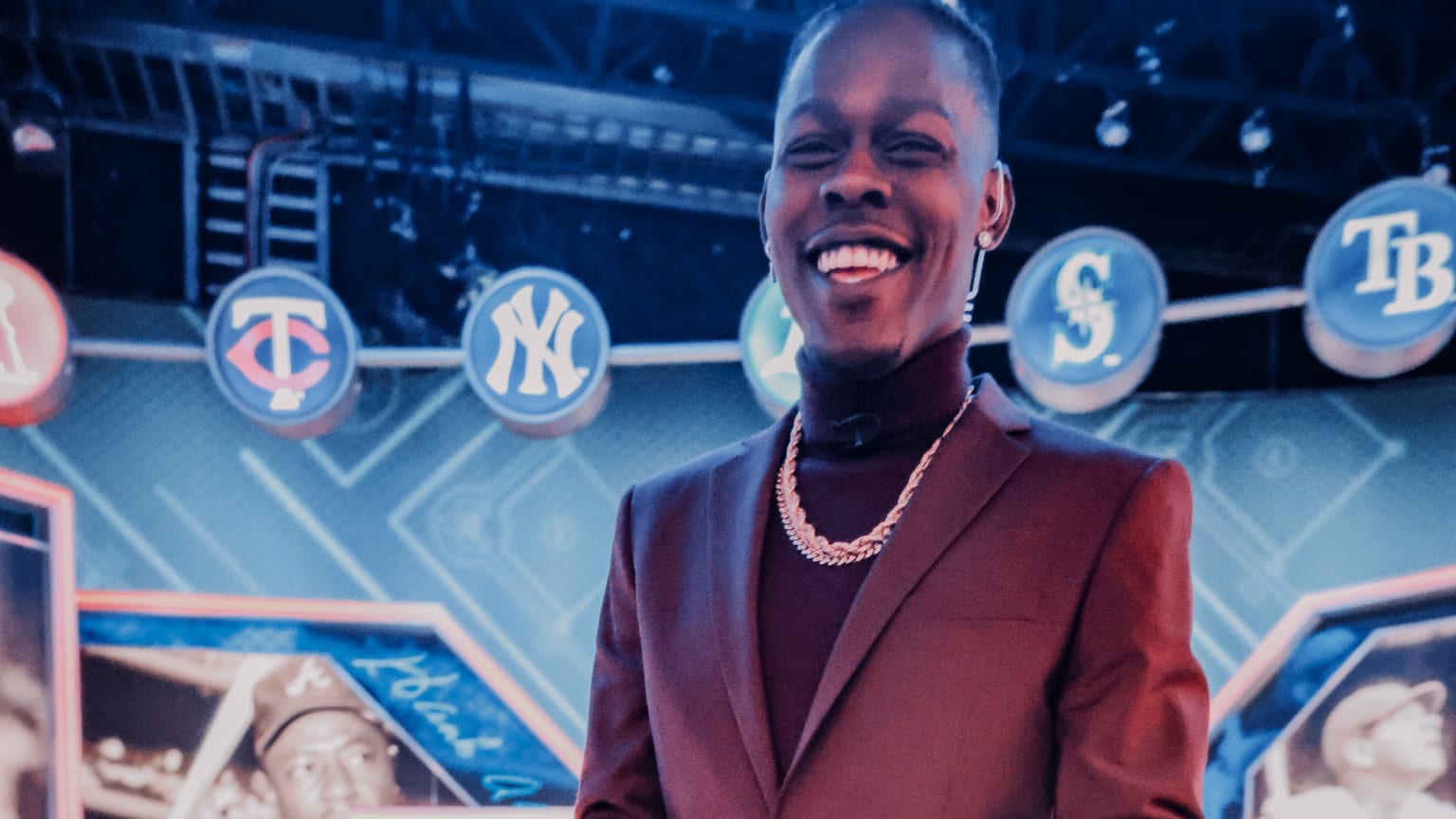 Jazz Chisholm Jr. smiles on an MLB Network set, wearing a burgundy suit