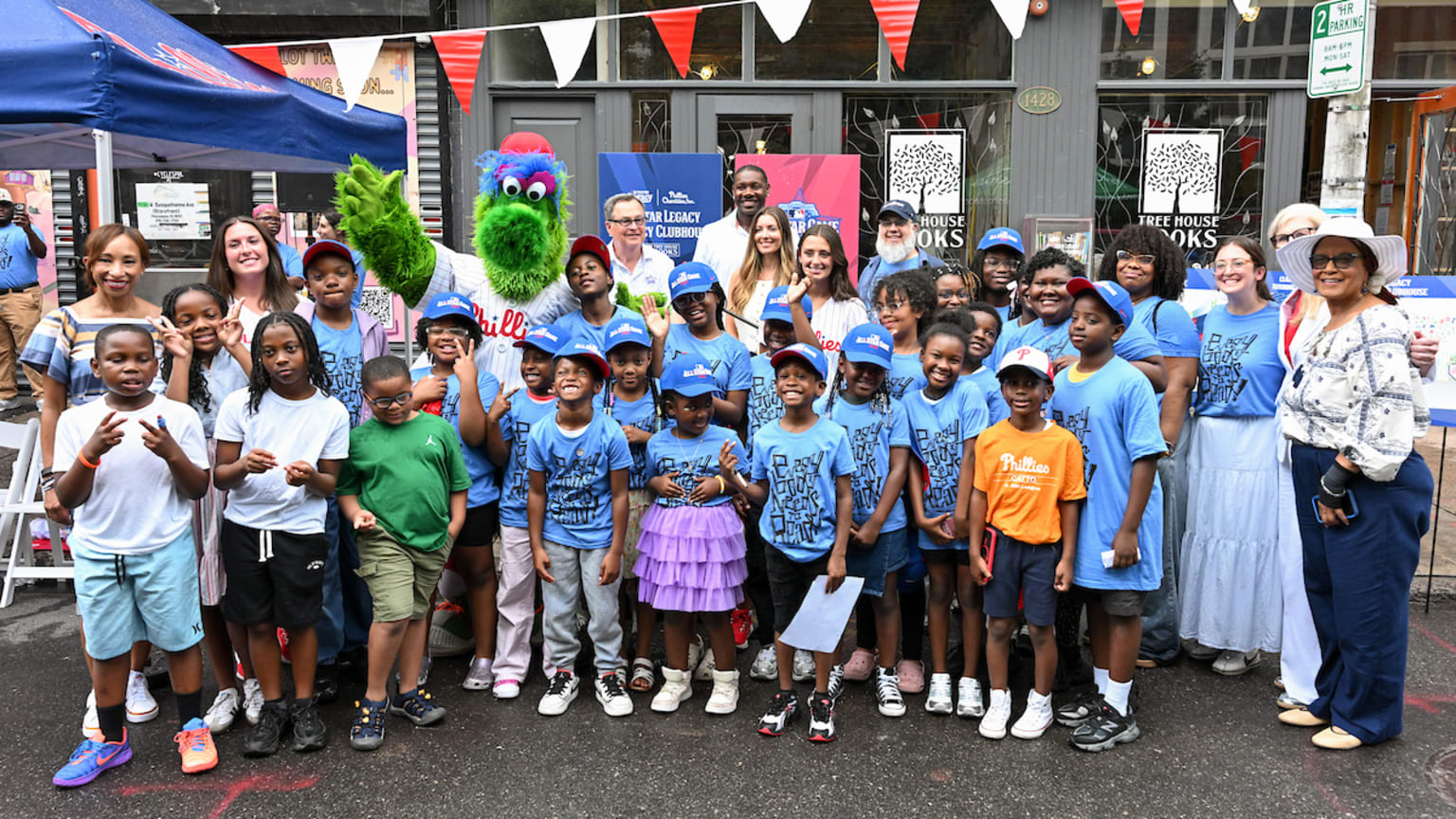 The Phillie Phanatic, local children and other dignitaries pose in front of a new Tree House Books location in Philadelphia