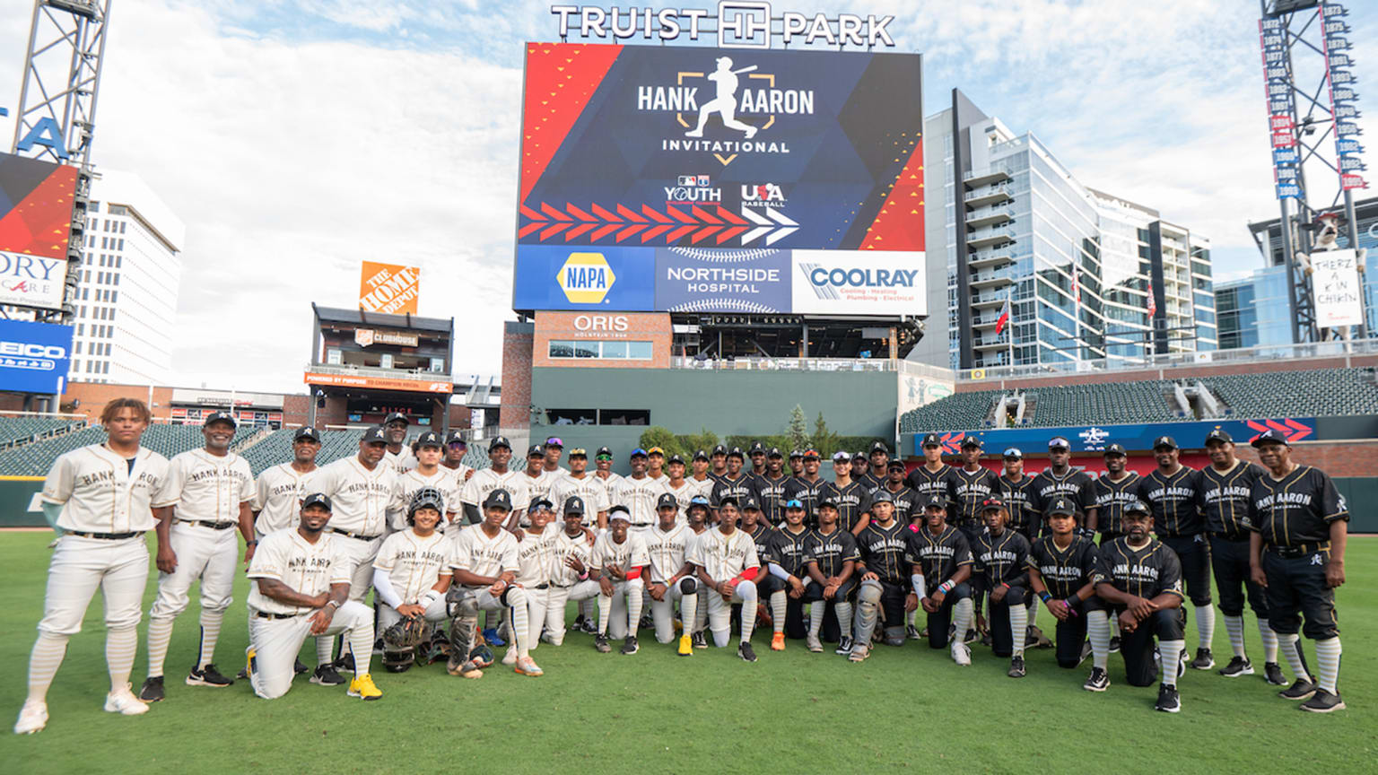 Two teams of high school-aged players pose on the field in Atlanta