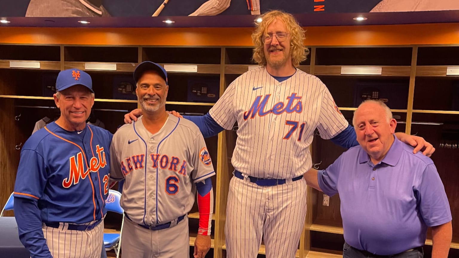 7-foot-2 Mets fan Alan Herbert poses for a photo with two former Mets players and P.R. person Jay Horwitz