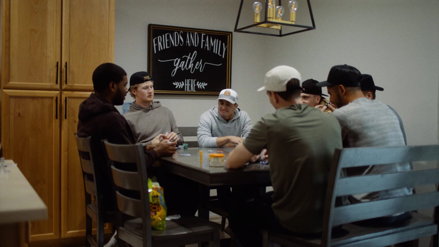 Seven men sit around a dining room table