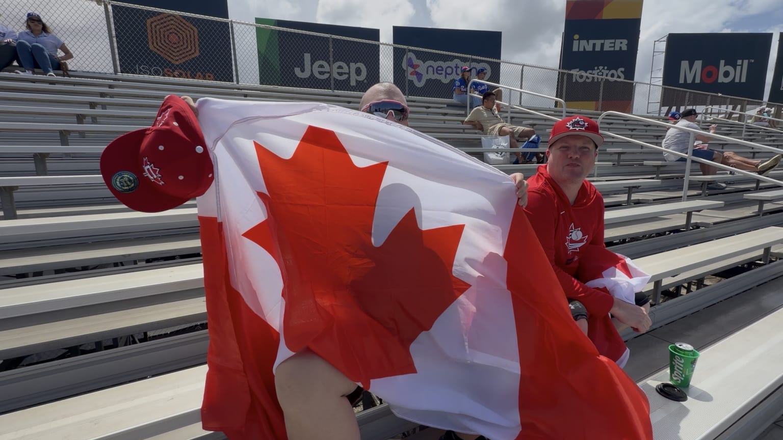 Two fans in the stands hold up a Canadian flag