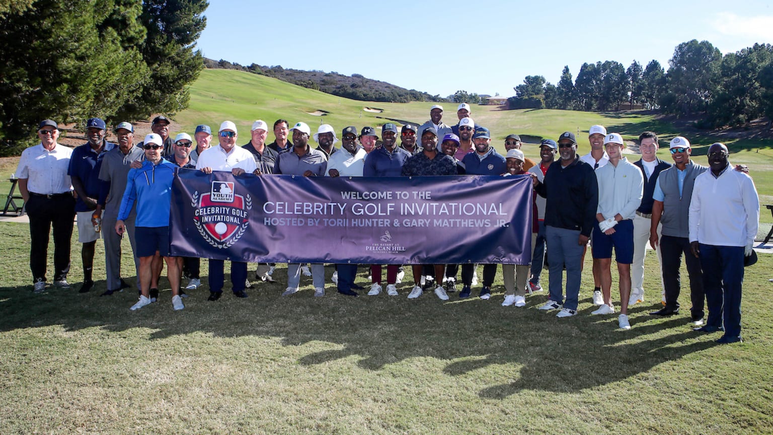 A group of people on a golf course holding a banner