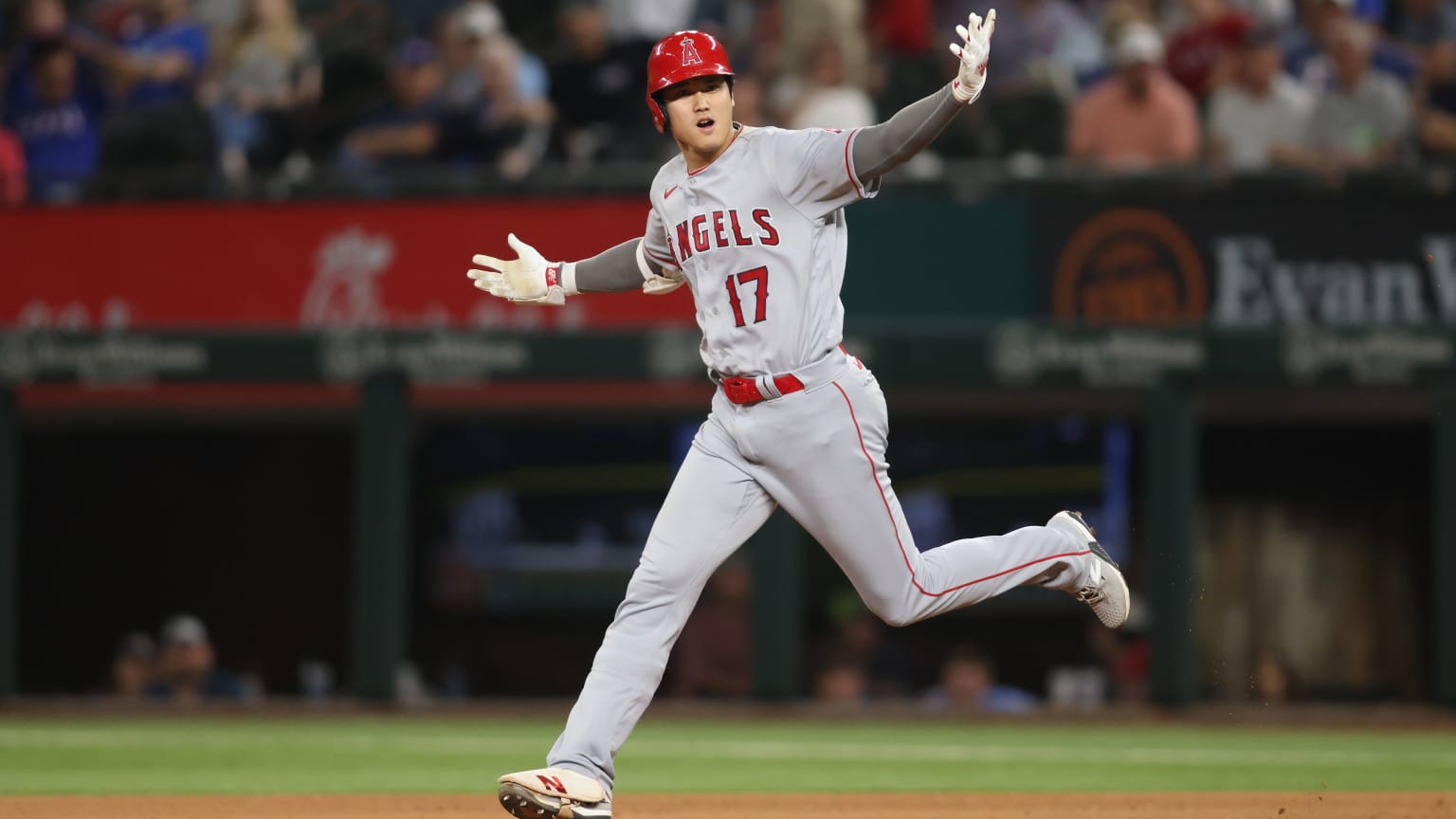 Shohei Ohtani throws his arms wide as he rounds the bases on a home run trot