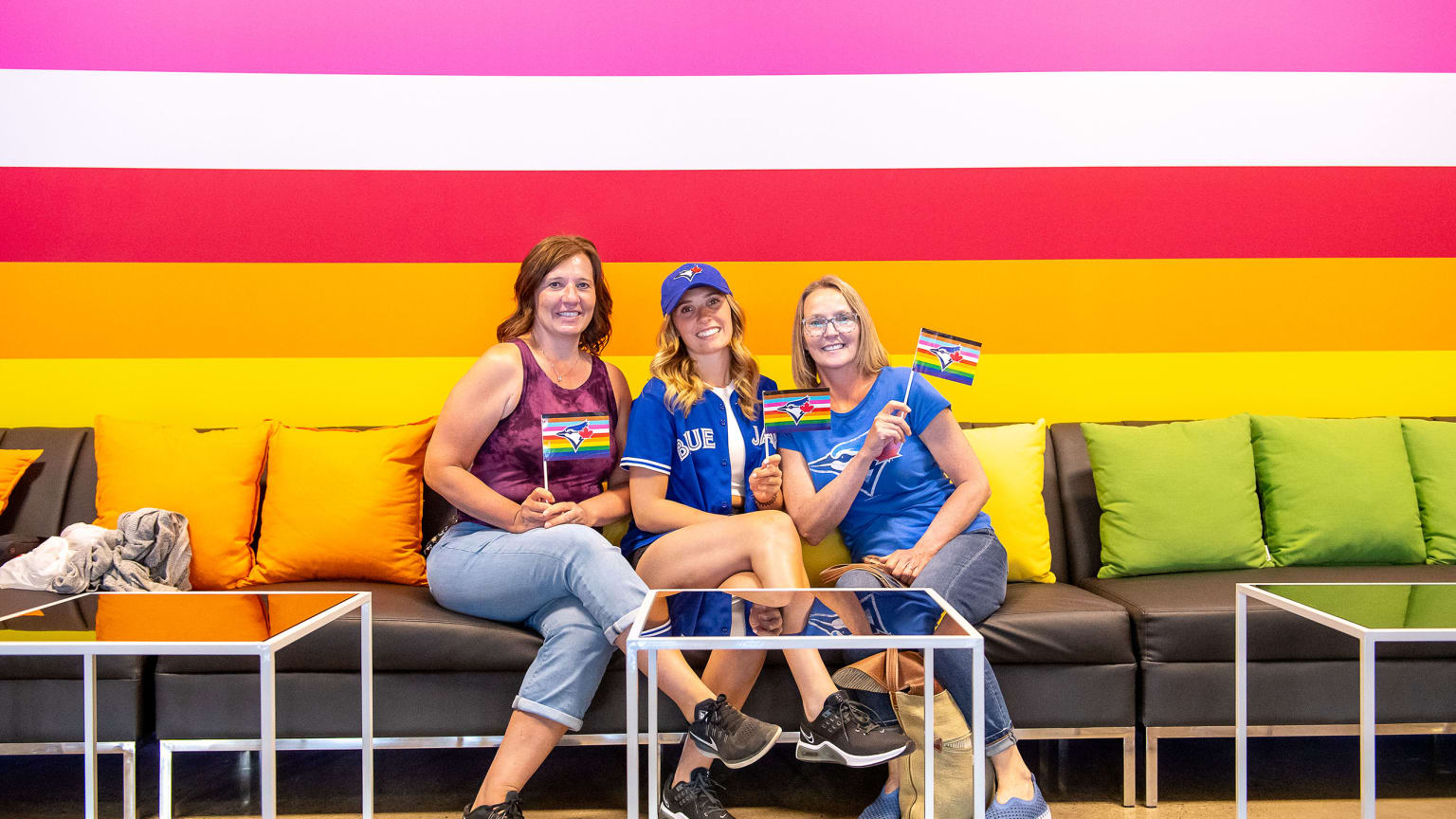 People hold a pride themed Toronto Blue Jays flag to celebrate Pride Weekend  before the Blue Jays play the Minnesota Twins in baseball game in Toronto  on Friday, June 9, 2023. (Mark