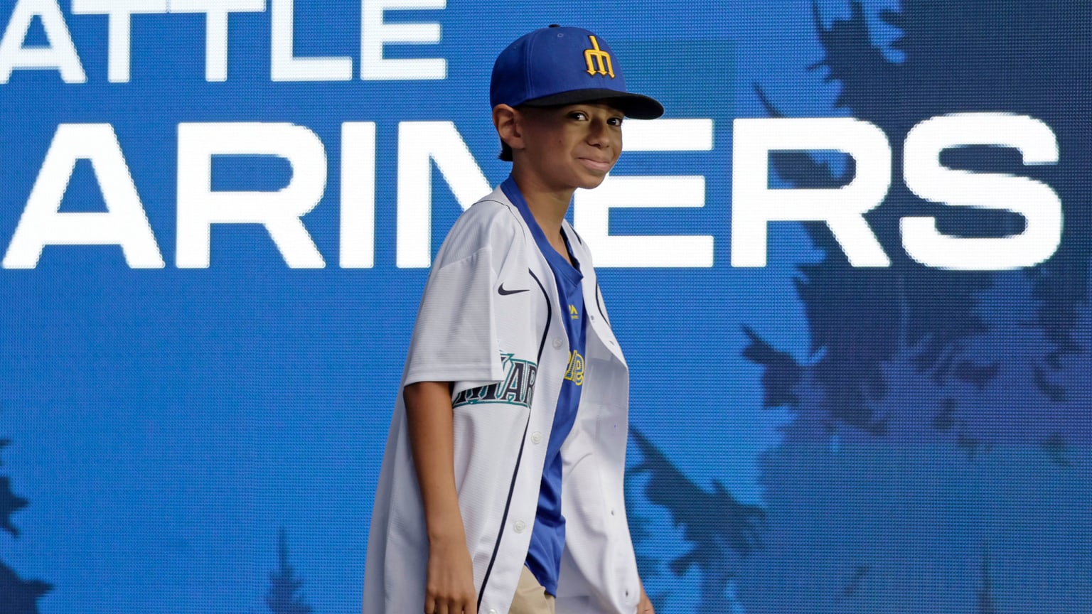 9-year-old Tiago Viernes walks onto the stage wearing a Mariners cap, jersey and T-shirt